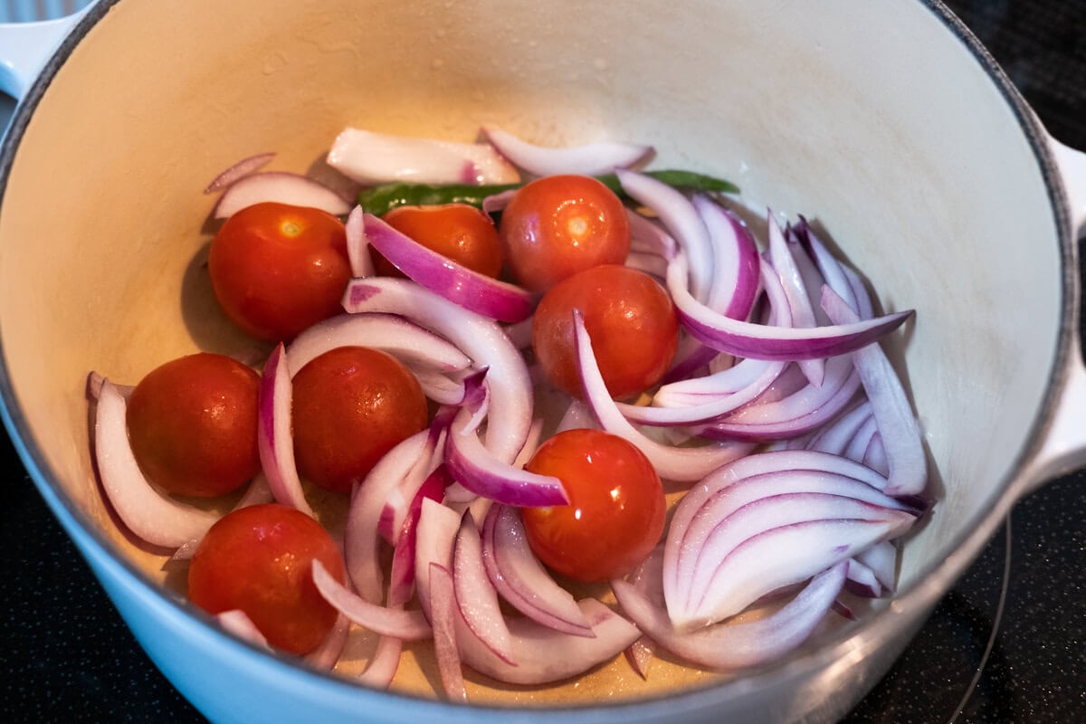 Sauté the red onion, tomatoes and green chili in a deep pot. 