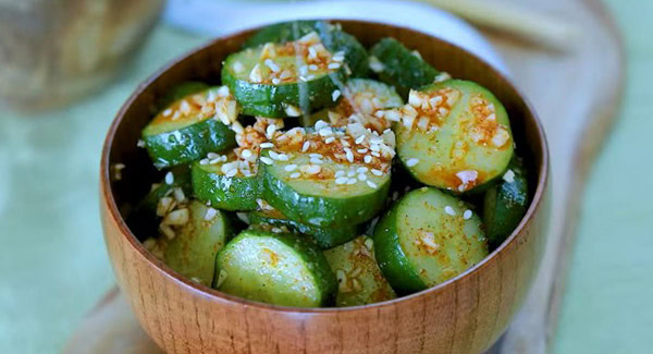 Topping Asian cucumber salad with sesame seeds