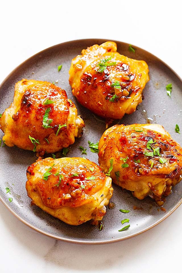 Baked chicken thighs in a serving platter.