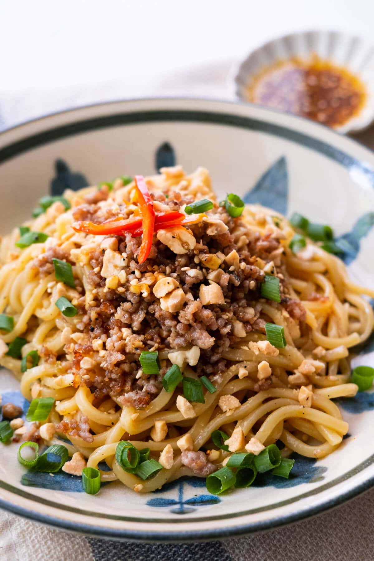 Dan Dan Mian topped with ground meat sauce and chopped scallion.