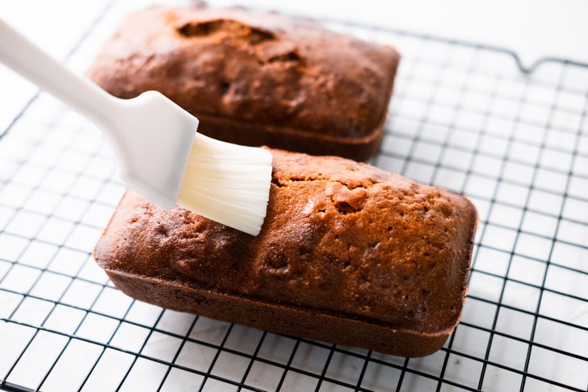 Place the Christmas fruit cake on a cooling rack and brush the top with brandy. 