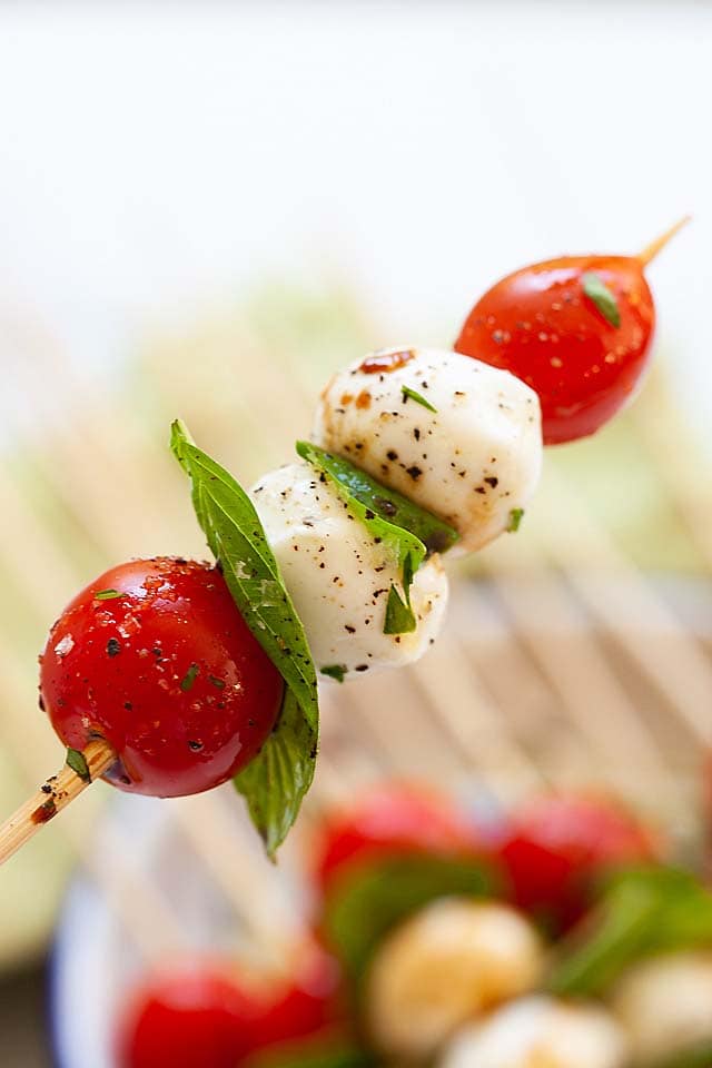 A close up of a single stick of Caprese skewer.