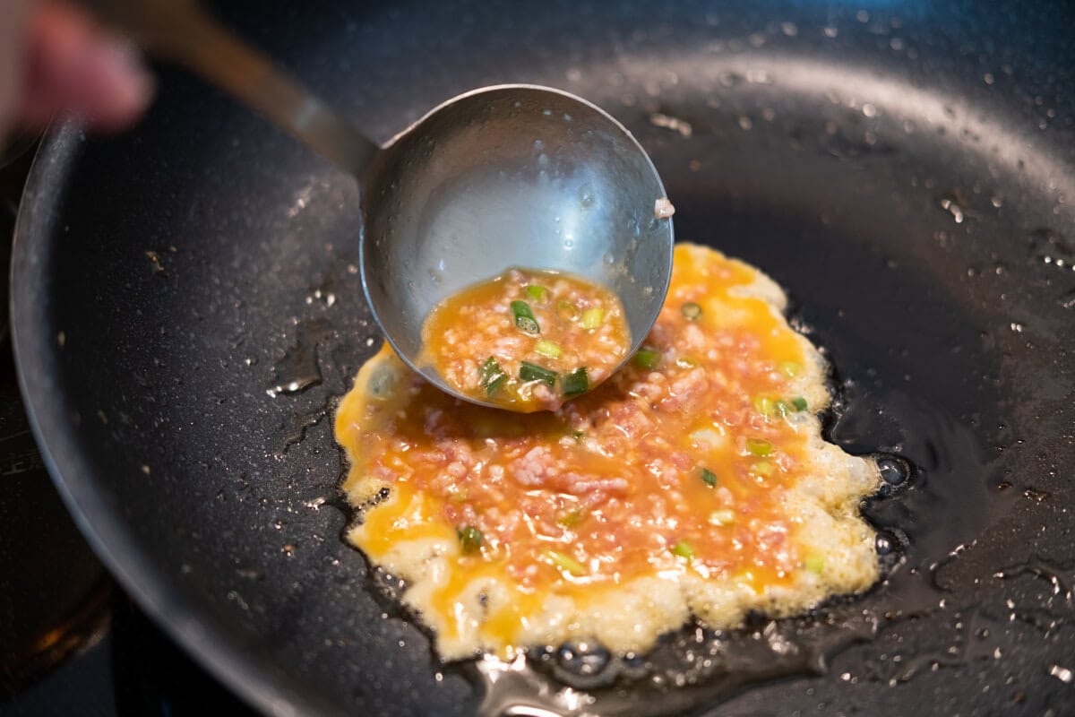 Egg foo young mixture cooked in a pan. 