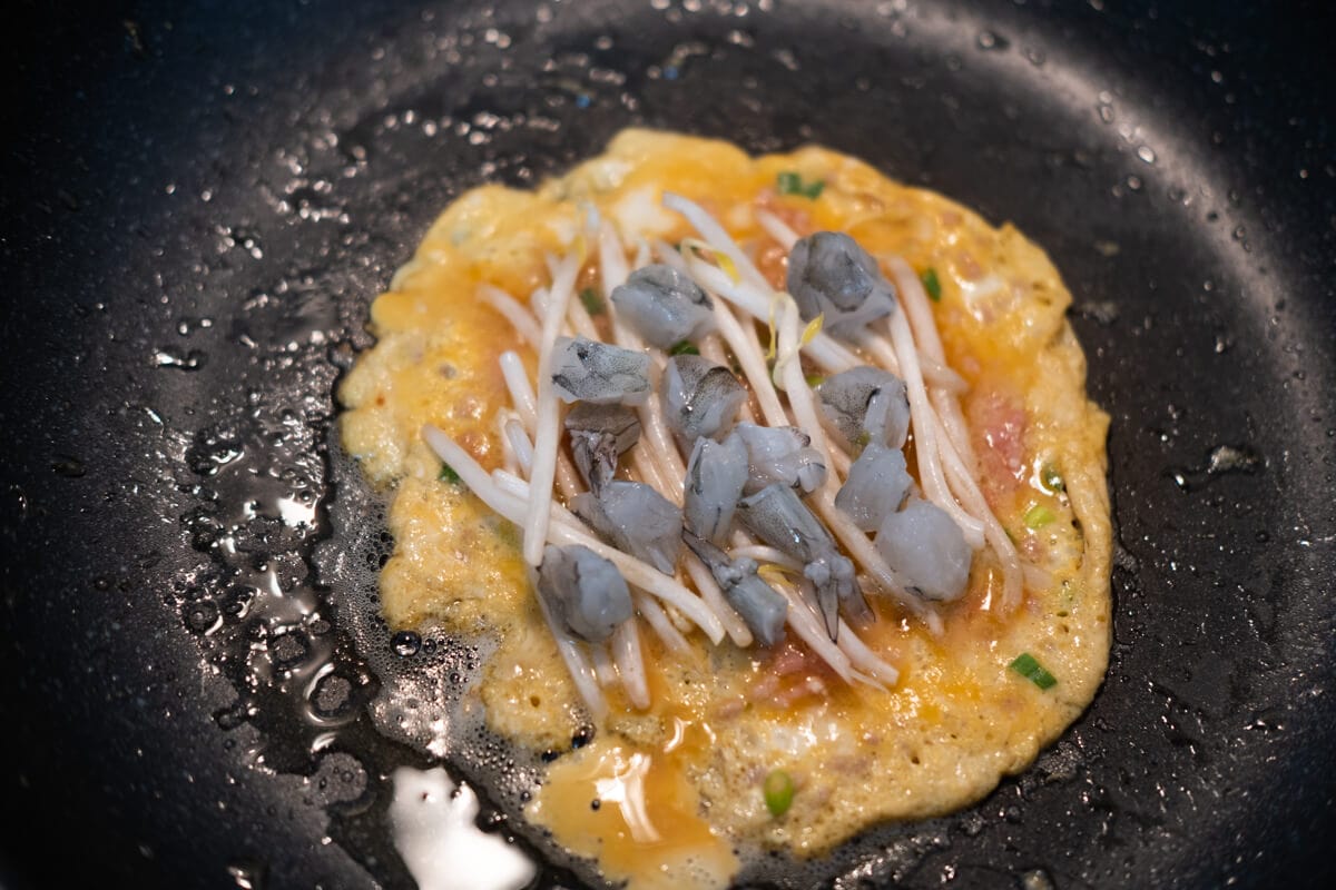 Adding bean sprouts and shrimp to the middle of egg foo young. 