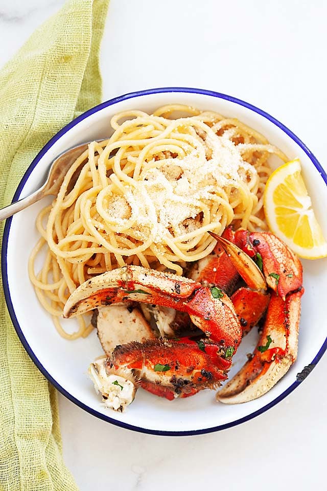 Asian garlic noodles with roasted crab on a serving platter. 