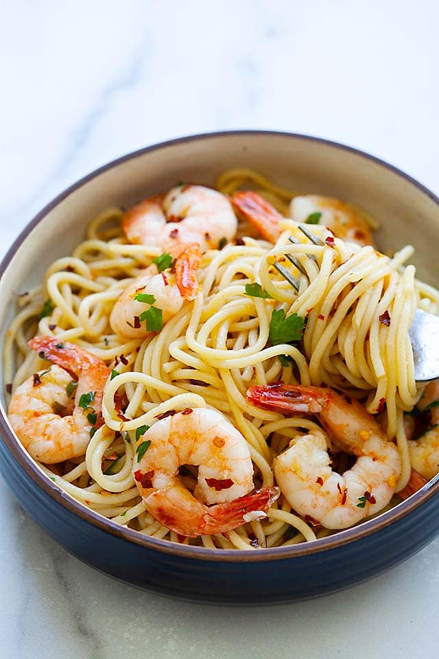 Aglio e olio recipe with shrimp, spaghetti, garlic and olive oil served on a plate. 