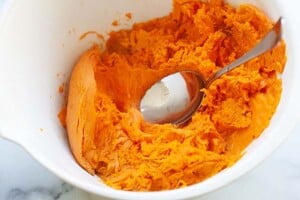 How to mash sweet potatoes using a spoon.