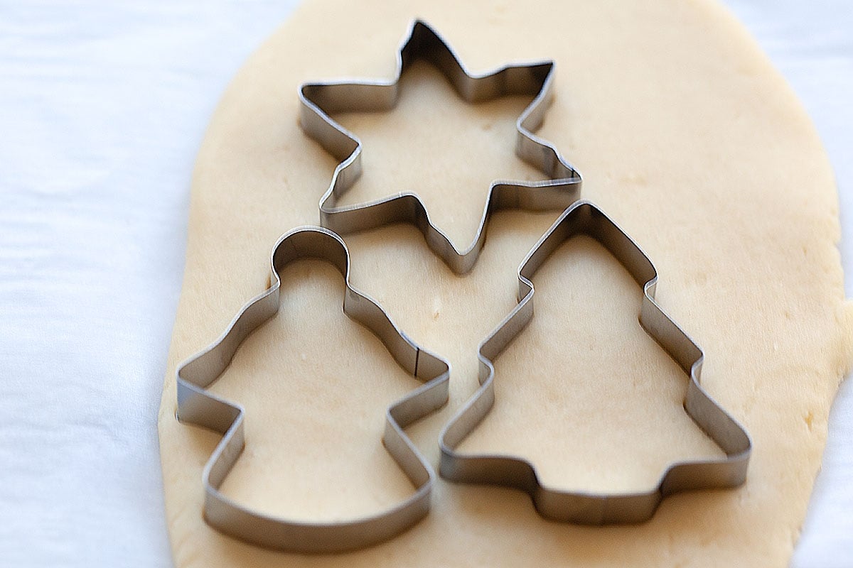 Butter cookies dough cut into different shapes with cookie cutter. 