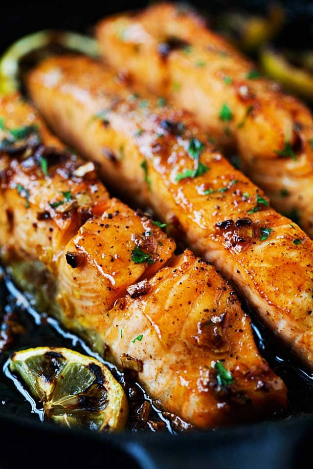 Salmon fillets cooked with honey garlic sauce on the stove.