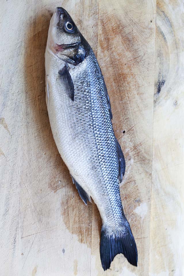 Whole Branzino on a cutting board.