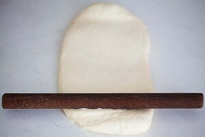 Using a rolling pin to roll Chinese steamed buns dough.