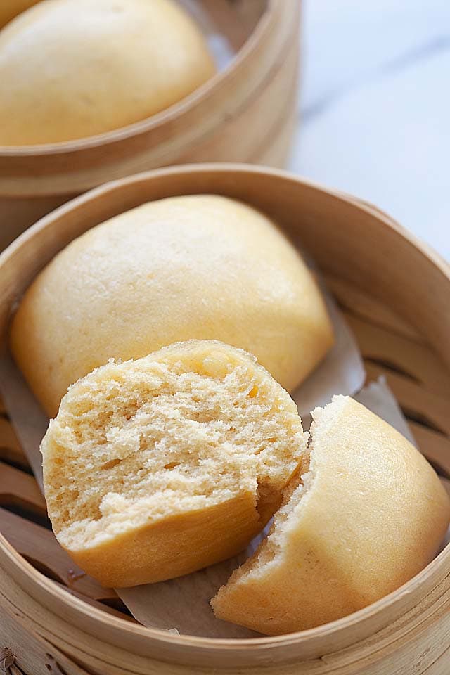 Mantou buns steamed in a bamboo basket.