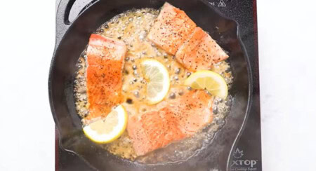 Cooking salmon fillets in a skillet.