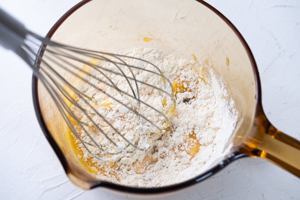 Whisk egg yolks and sugar in a saucepan, then add all-purpose flour. 