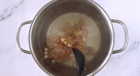 Making shrimp stock with shrimp heads and shells in a pot of boiling water.