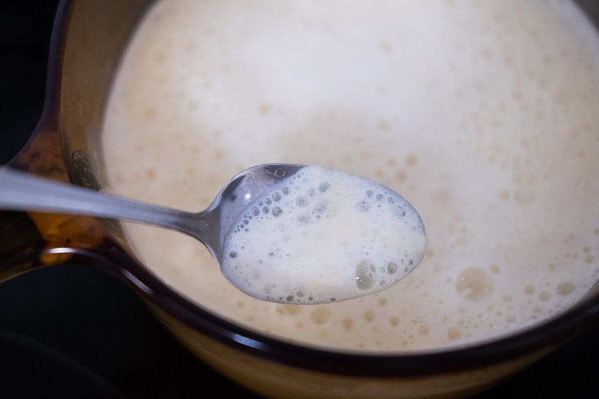 Skim off the foam and bubbles of the boiling soy milk in a saucepan. 