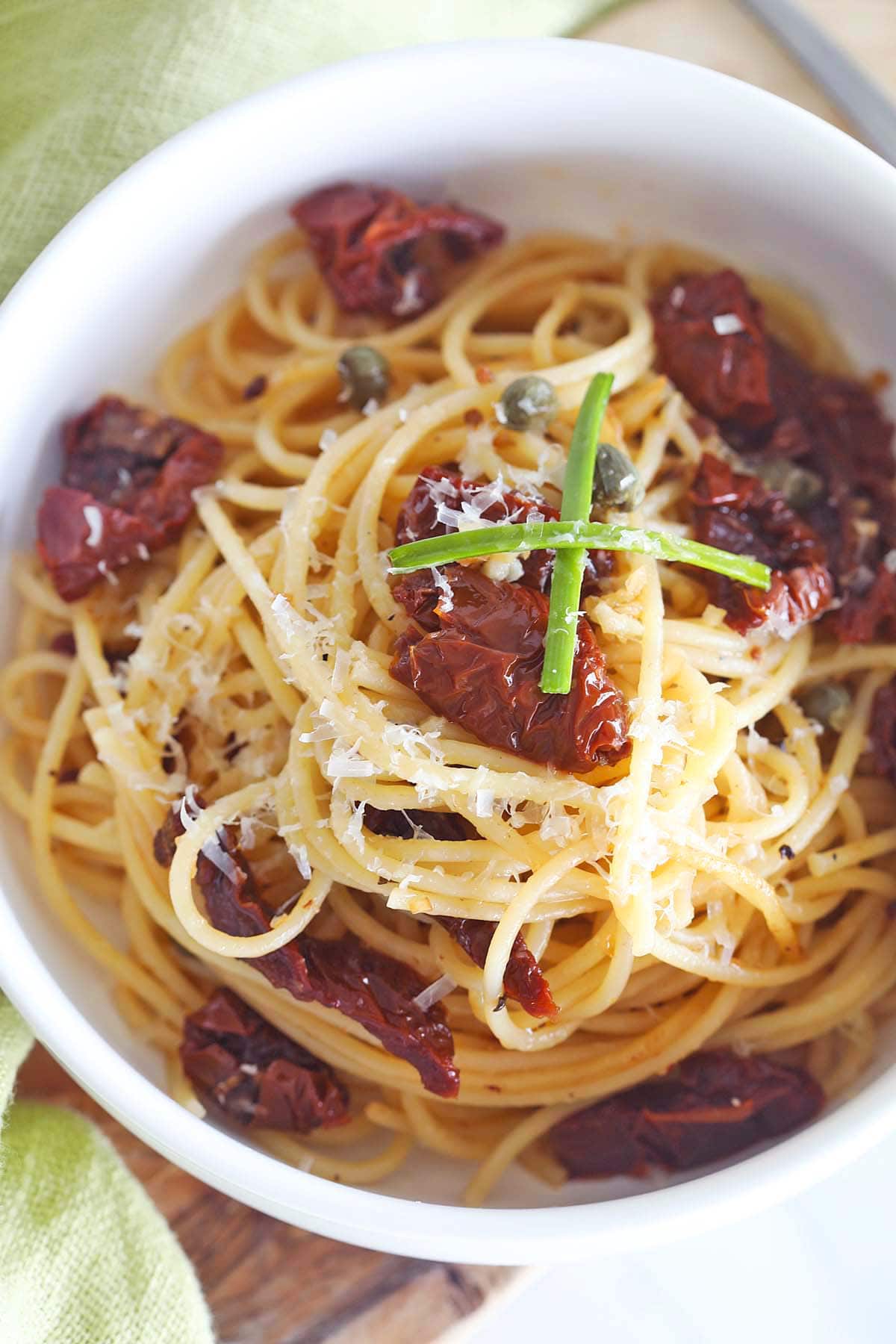 Sun dried tomato pasta recipe with spaghetti, sun dried tomatoes and shaved parmesan cheese.