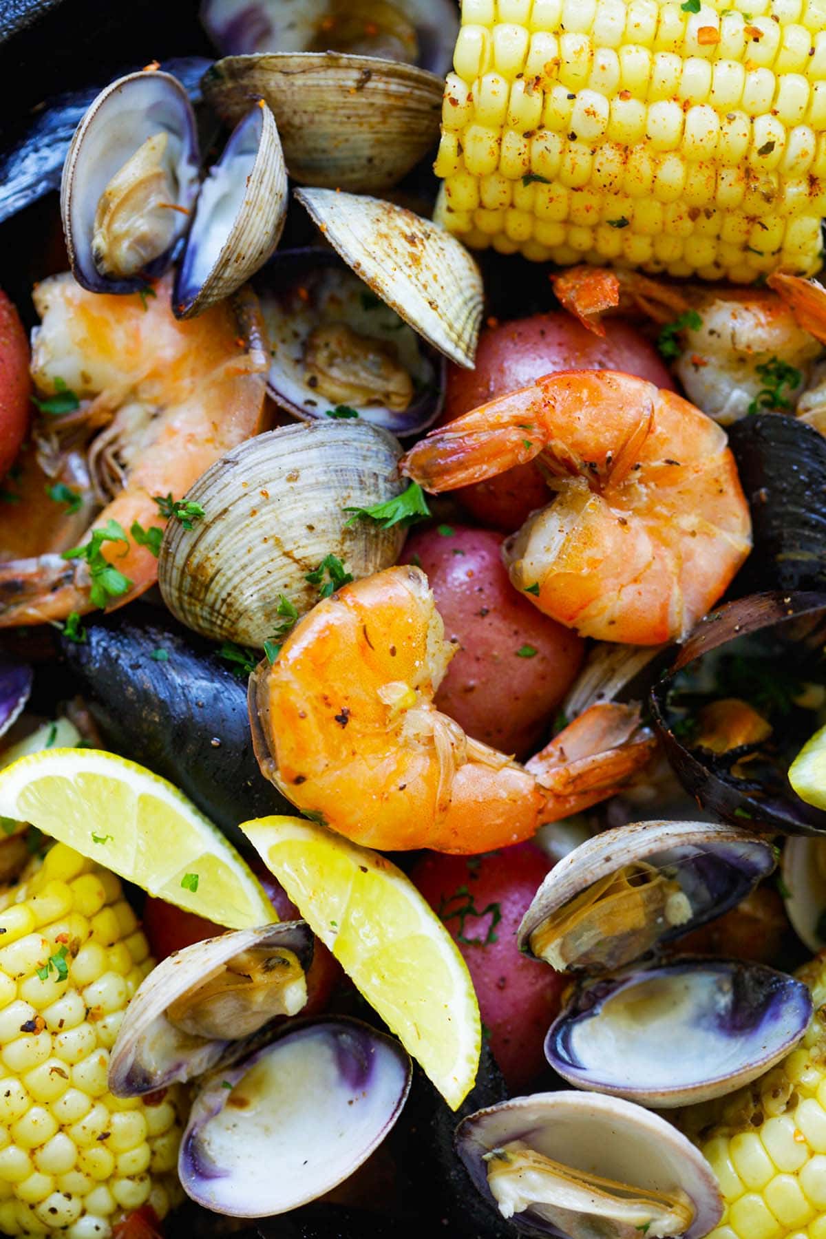 Traditional clambake recipe with seafood in a skillet.