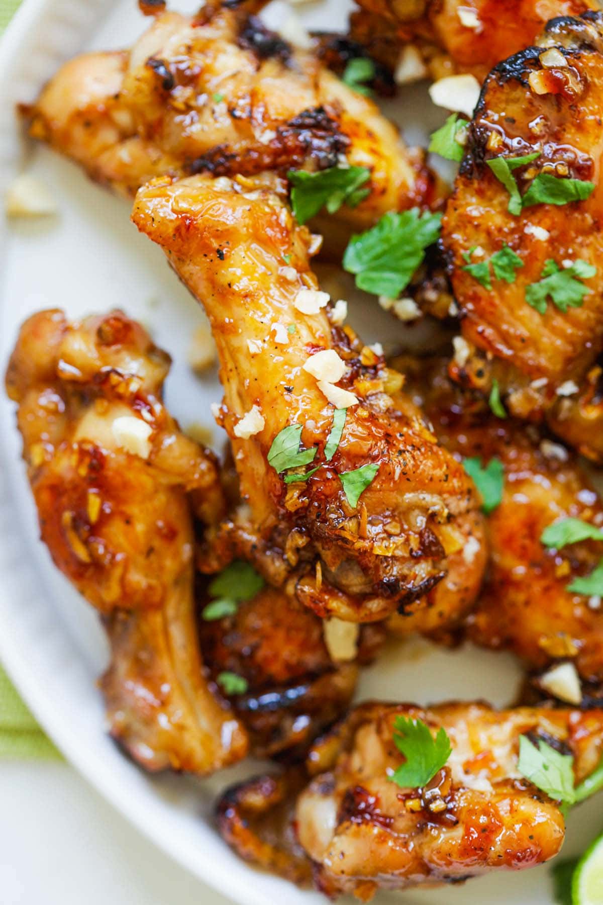 Close up chicken wings coated with savory, sweet and sticky honey garlic chili sauce.