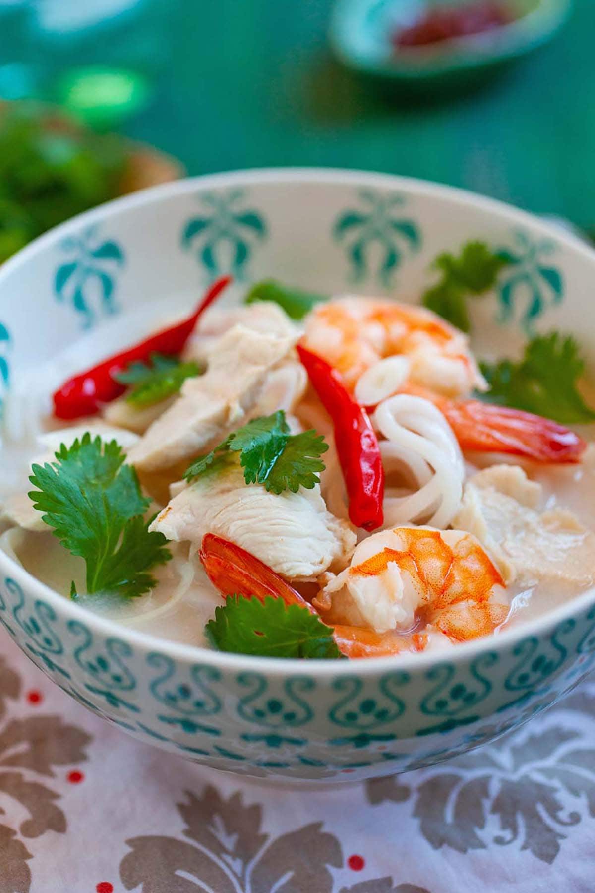 Rich and tasty homemade Thai coconut lime noodle soup with shrimps ready to serve.