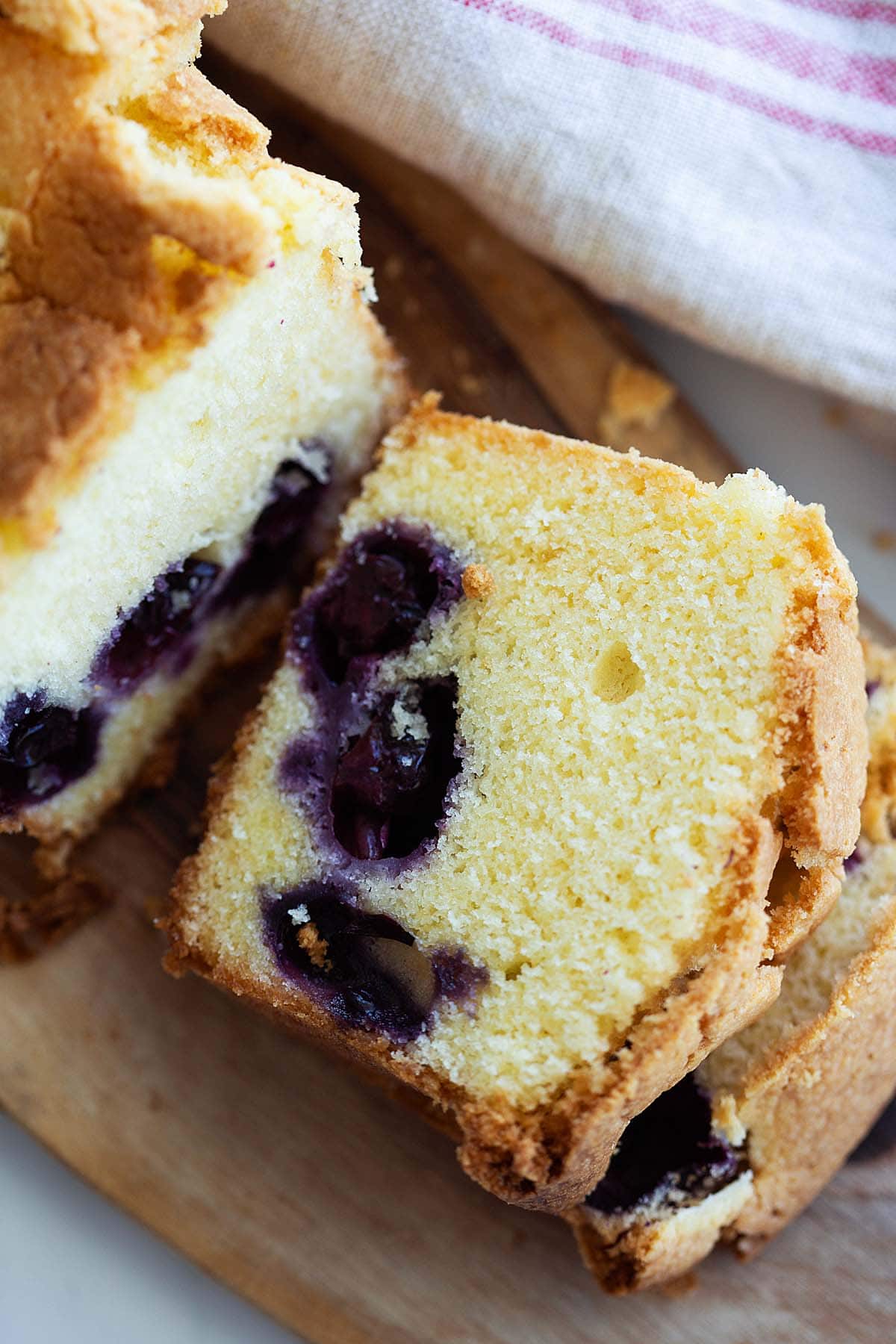 Cake with golden-brown crust and abundant of juicy blueberries in between the yellow cake. 
