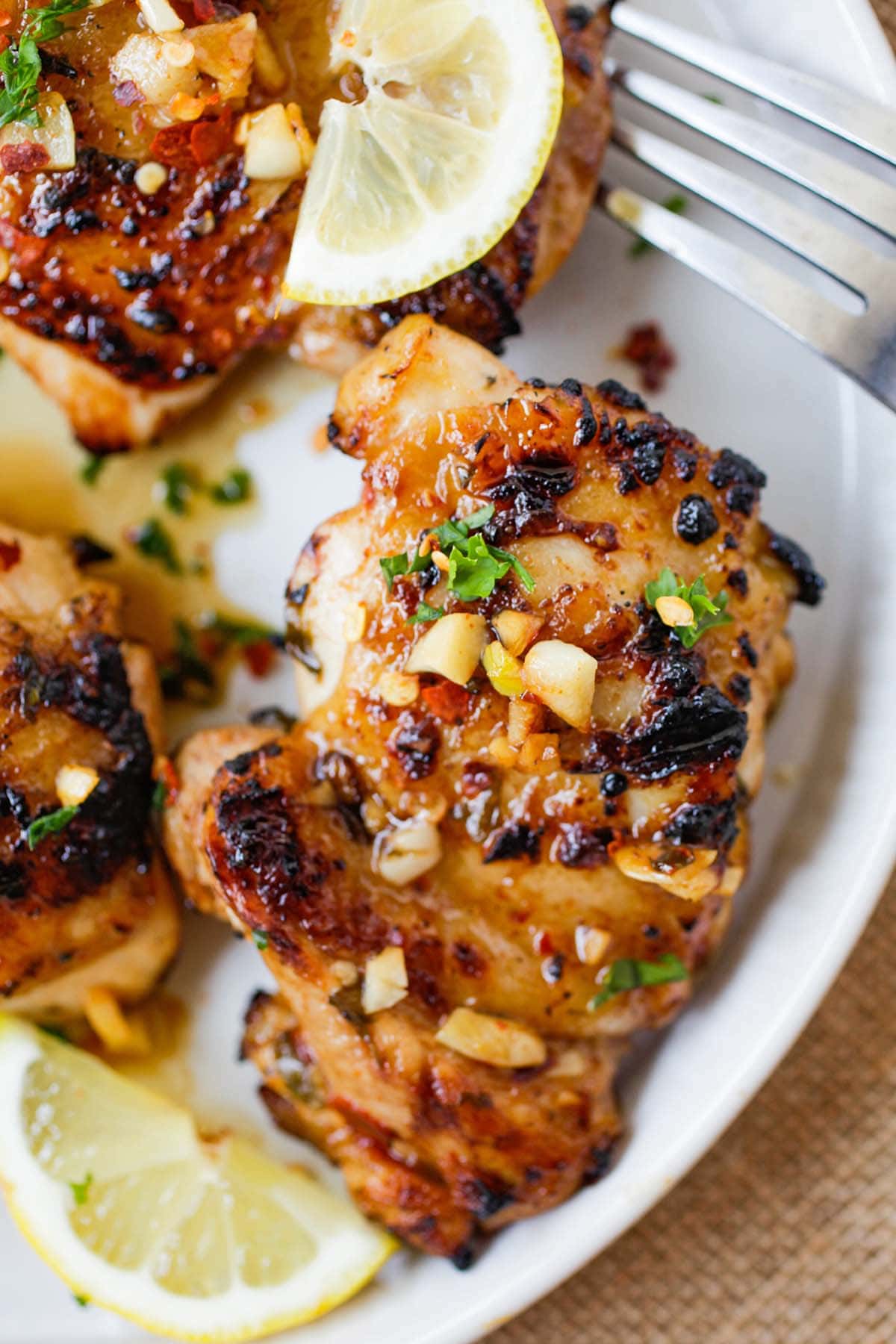 Close up shot of chicken marinade in lemon and garlic served on a plate.