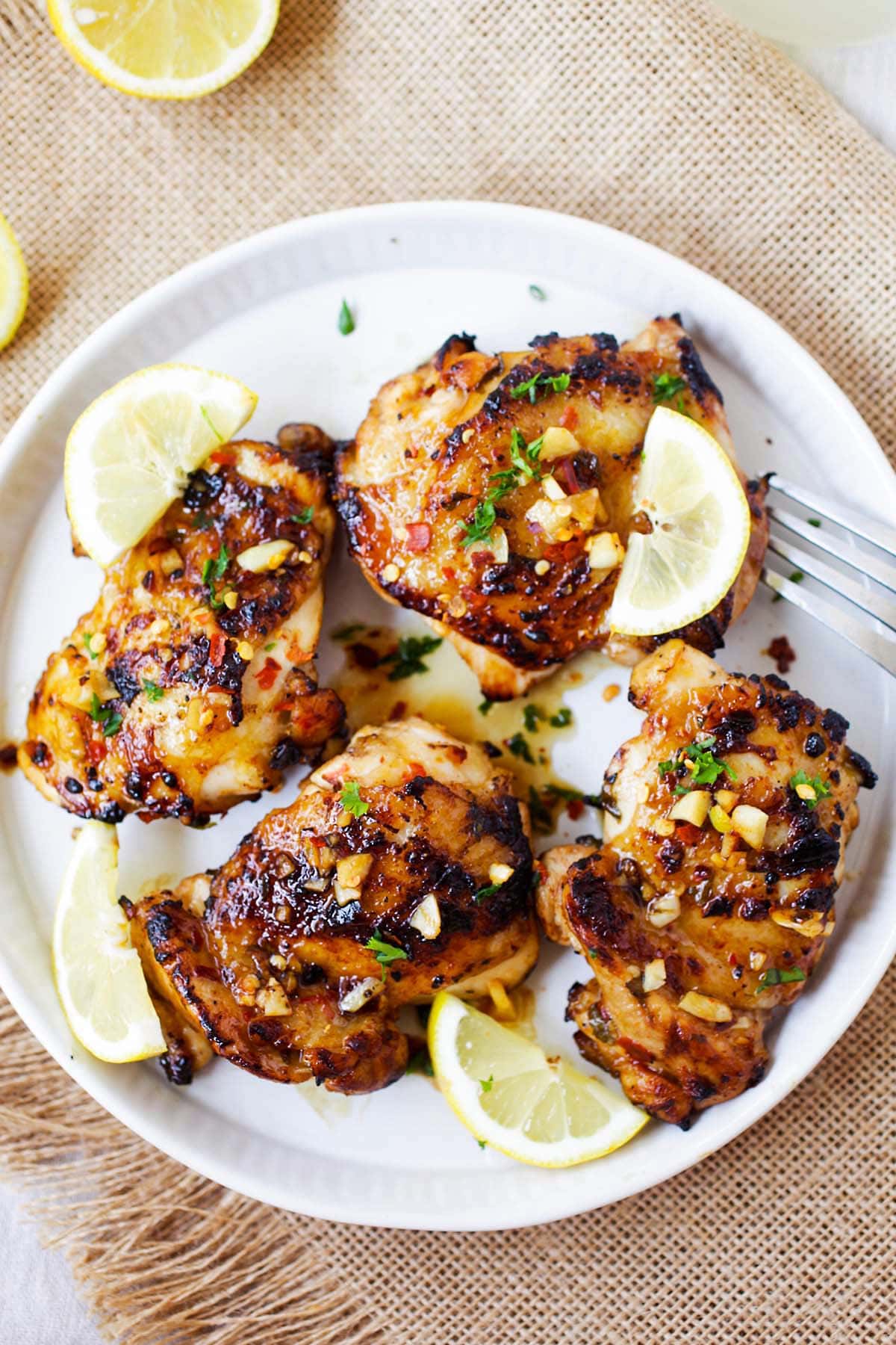 Easy and Delicious Lemon Garlic chicken recipe, featuring chicken covered in lemon, garlic, honey, and parsley.