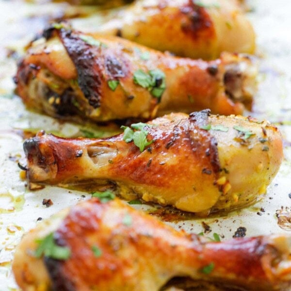 Juicy oven baked Thai chicken drumsticks on parchment paper.