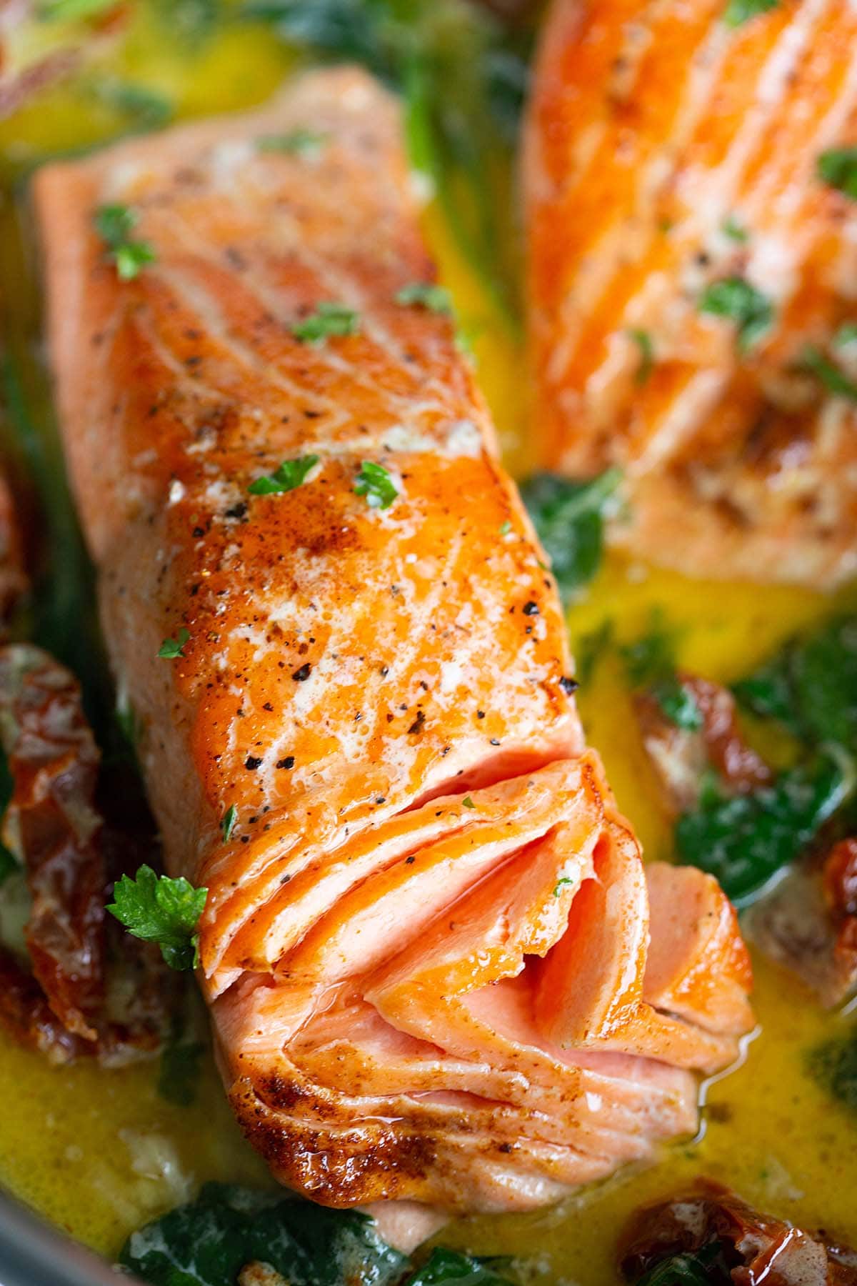 Creamy garlic butter coated salmon in a skillet.