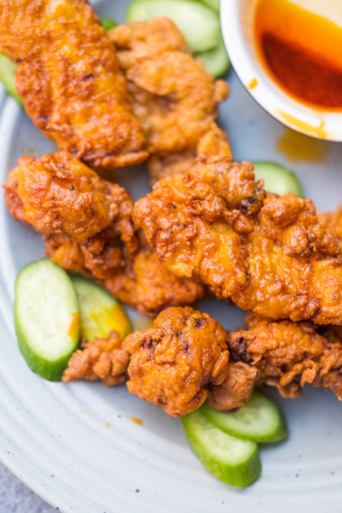 Nashville fried chicken with cucumber and extra hot spiced oil served on the side. 