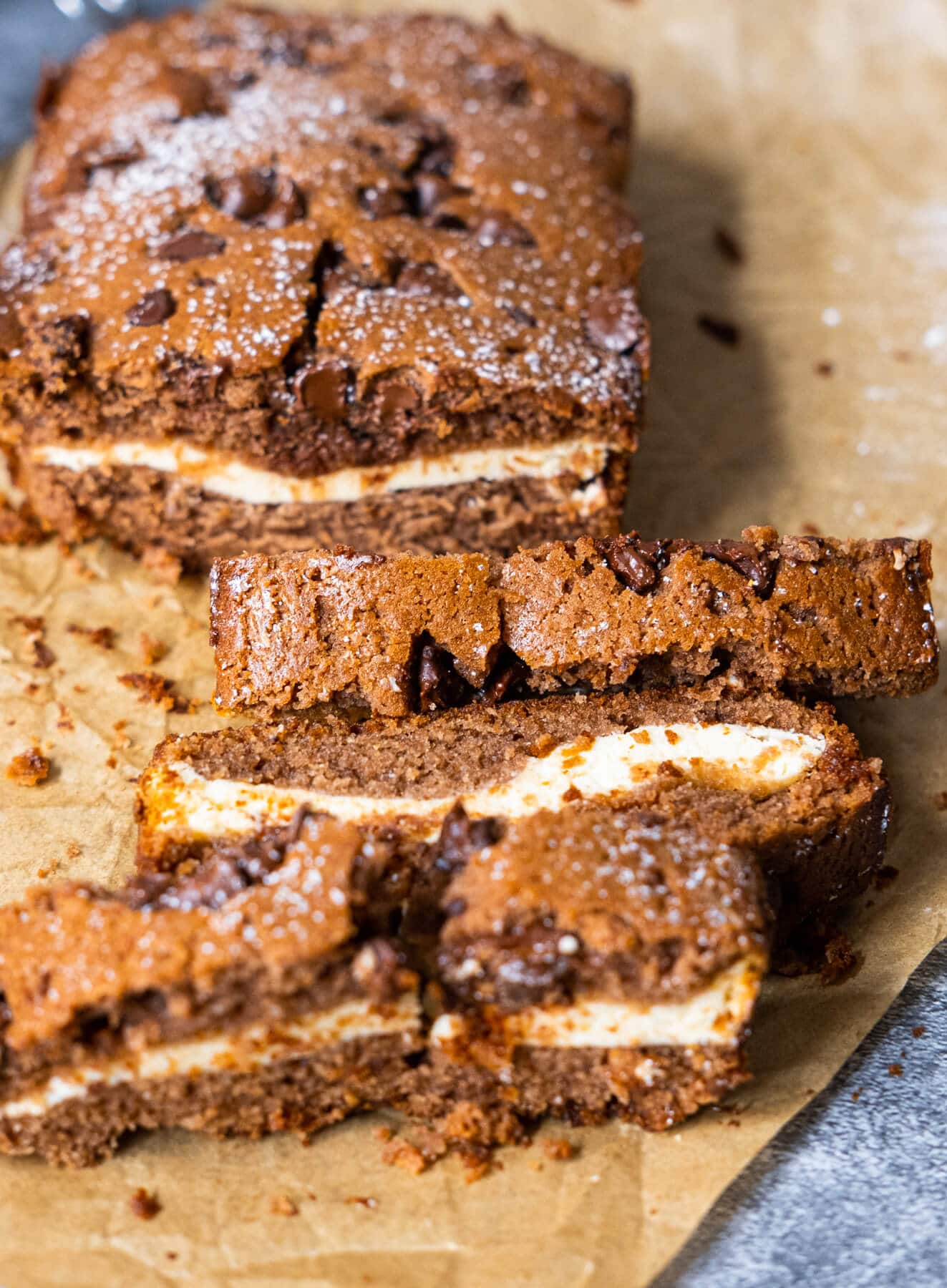A tempting close-up of a cake, featuring layers of moist chocolate cake generously coated with a velvety cream cheese frosting and beautifully garnished with chocolate curls.