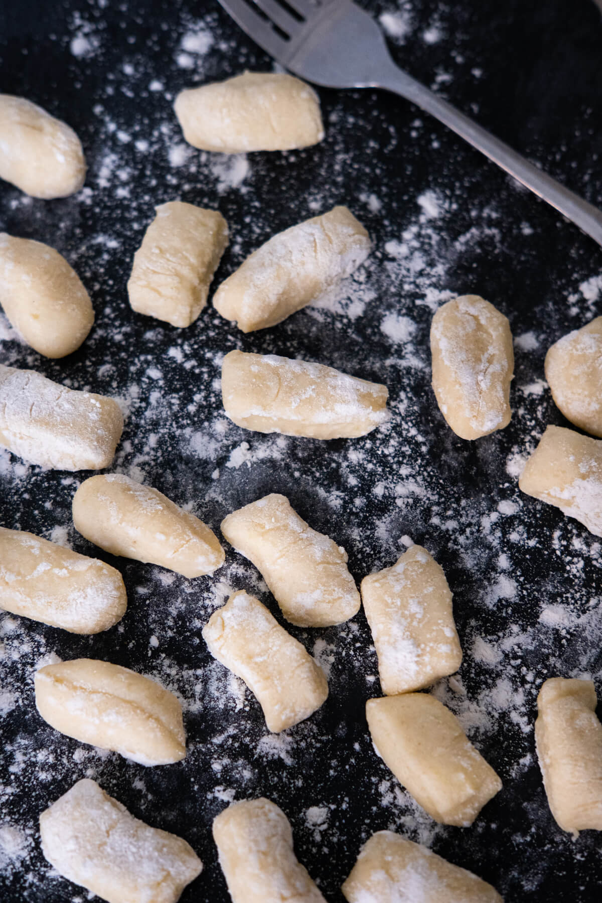 Gnocchi dusted with flour on a working surface.
