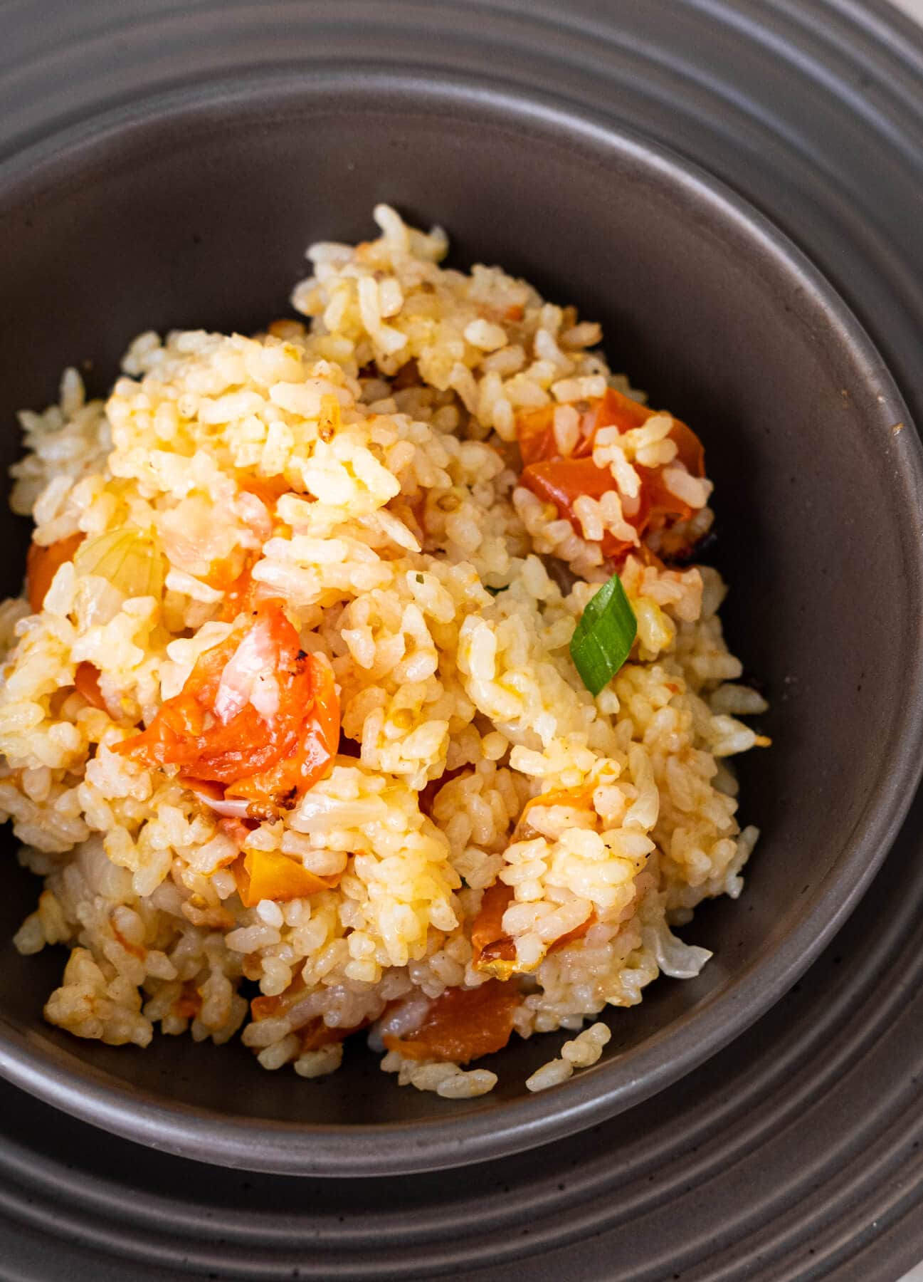 A close up shot of homemade yellow Spanish rice with onion, garlic and bay leaves with it. 