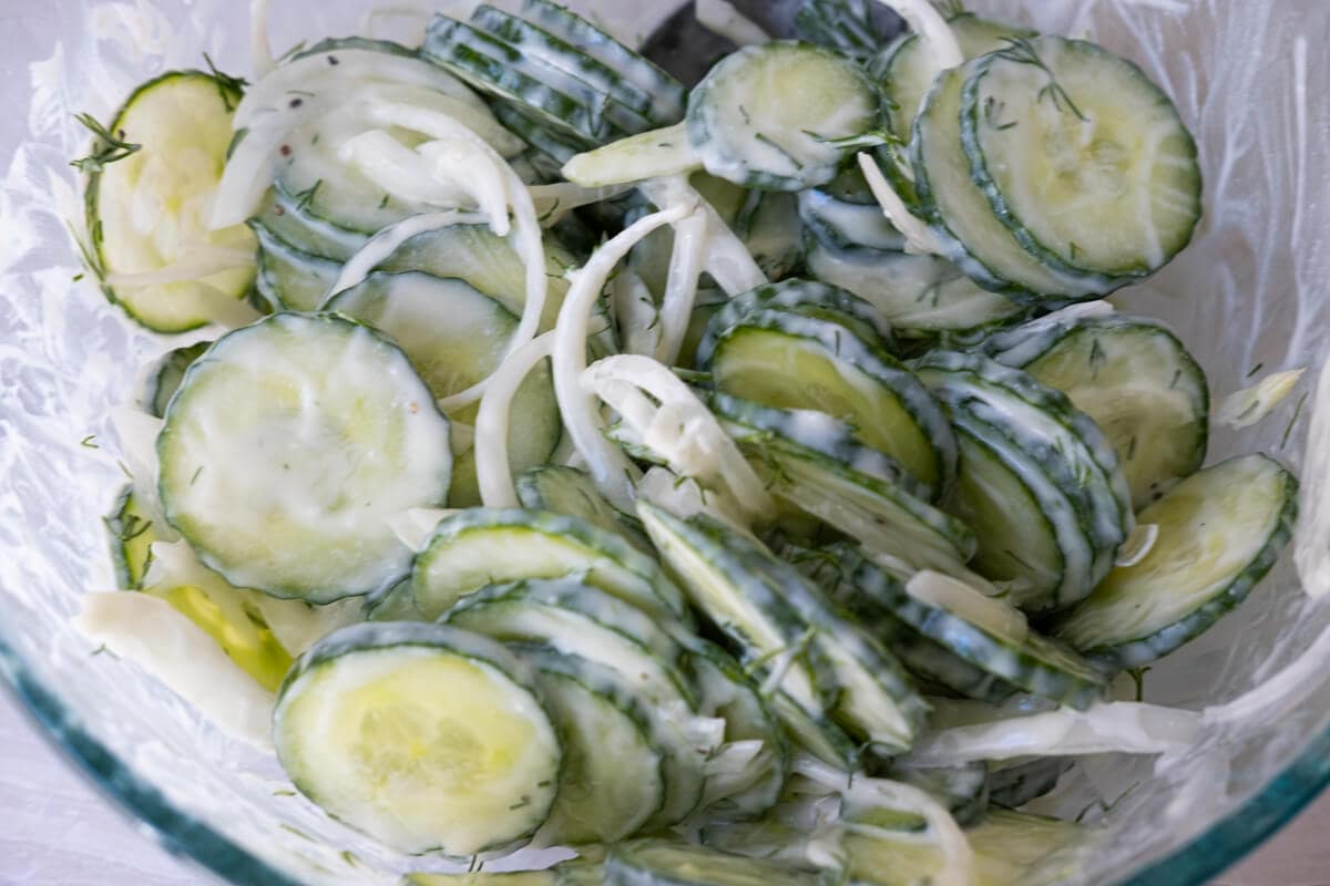 Toss cucumber slices and salad dressing very well in a bowl.