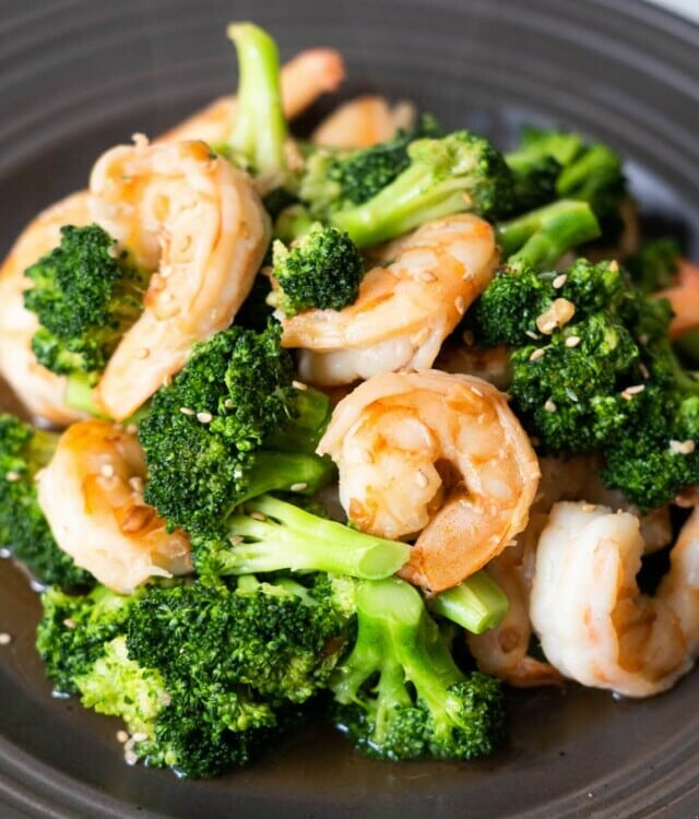 Shrimp and broccoli stir-fry with white sesame seeds sprinkled on top.