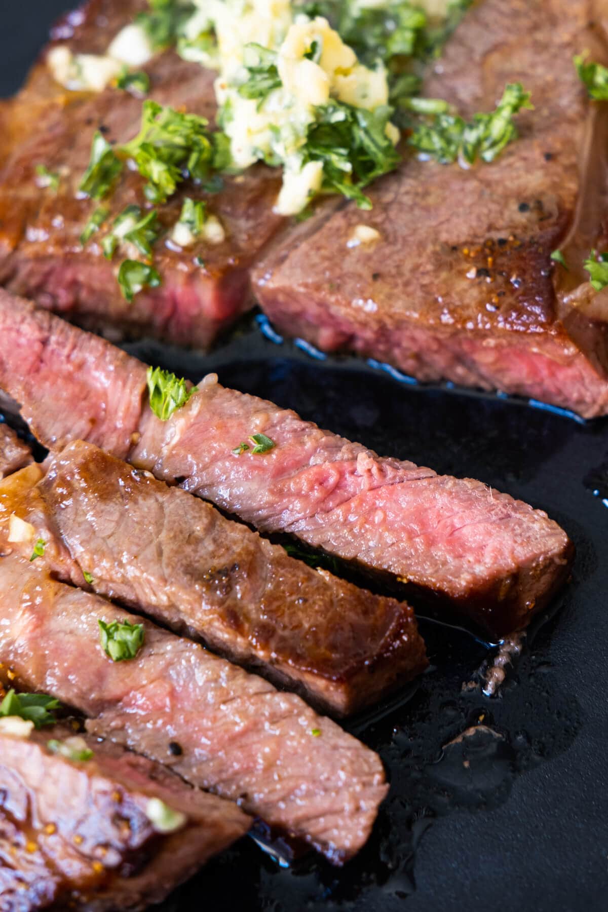 Soft and tender wagyu beef cut into slices and topped with garlic butter and chopped parsley.