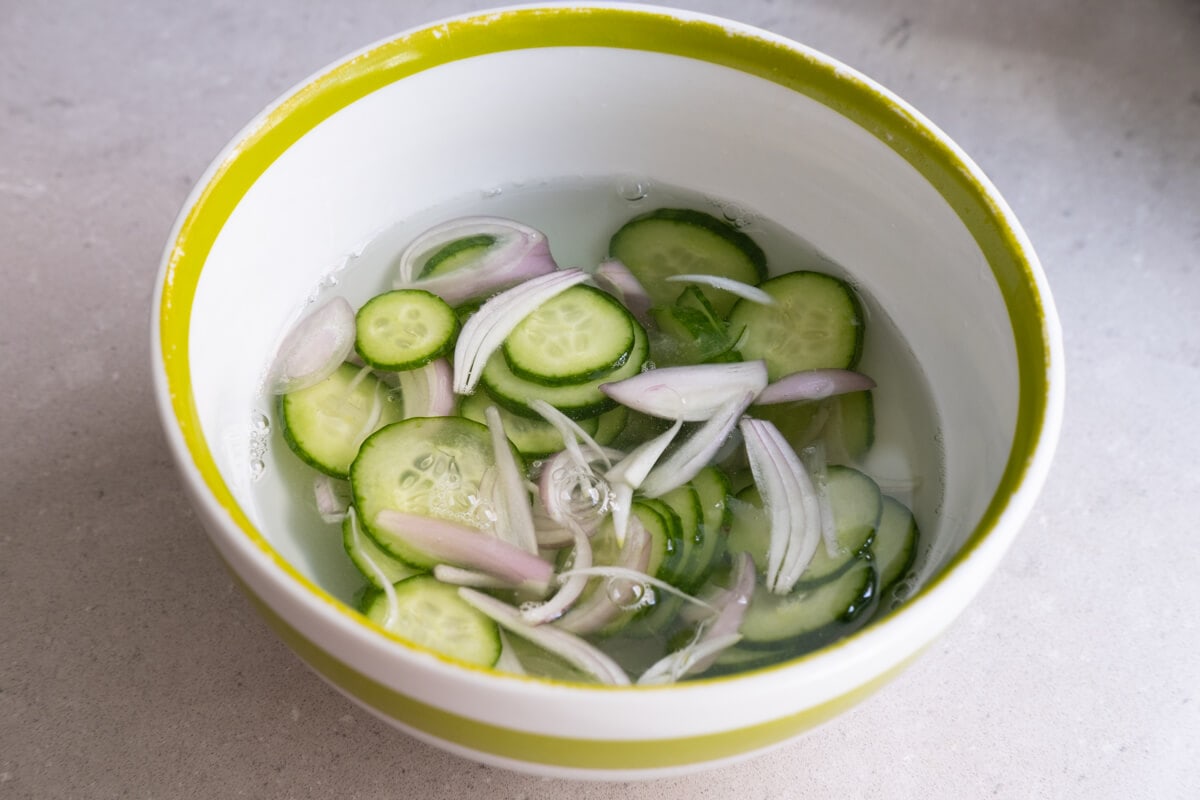Soak both cucumber slices and shallot slices in salted water. 