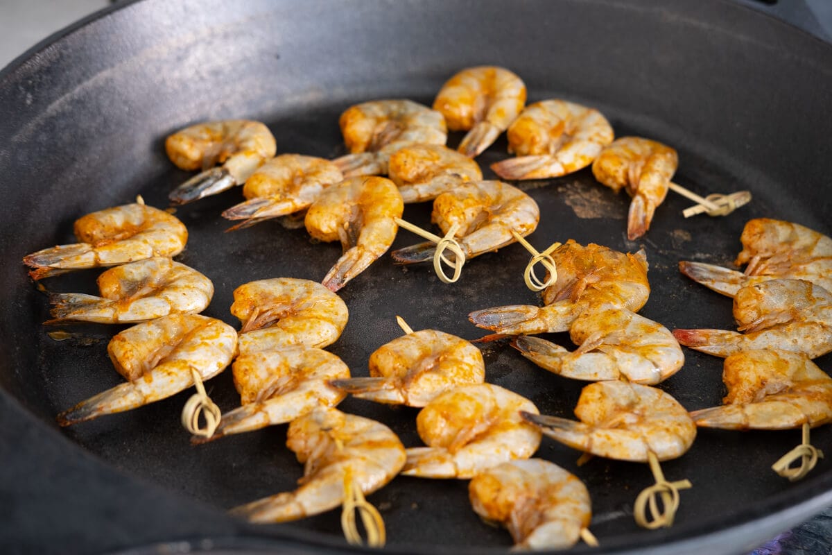 Grill Old Bay shrimp skewers on cast iron pan. 
