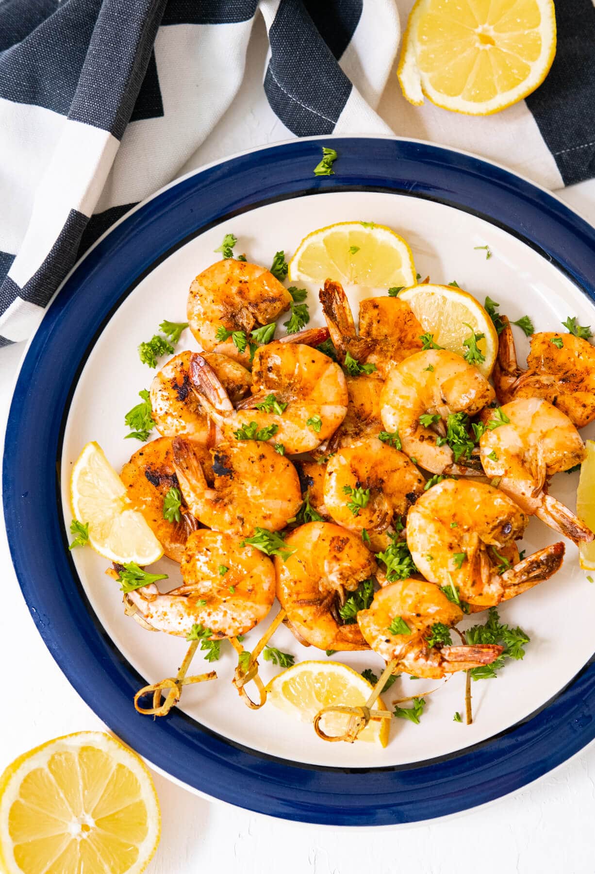 Old bay shrimps served on a plate with lemon wedges. 