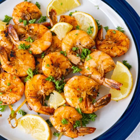 Old bay shrimp served with chopped parsley and lemon wedges.