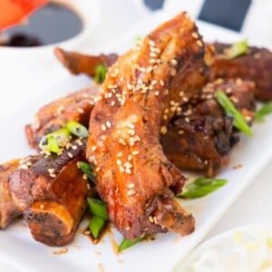 Slow cooker teriyaki ribs topped with white sesame seeds and chopped green onion.