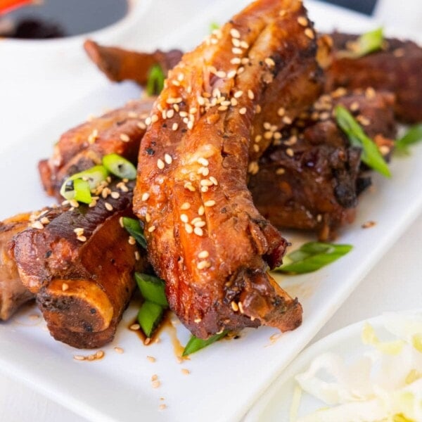 Slow cooker teriyaki ribs with white sesame seeds and chopped green onion on top.