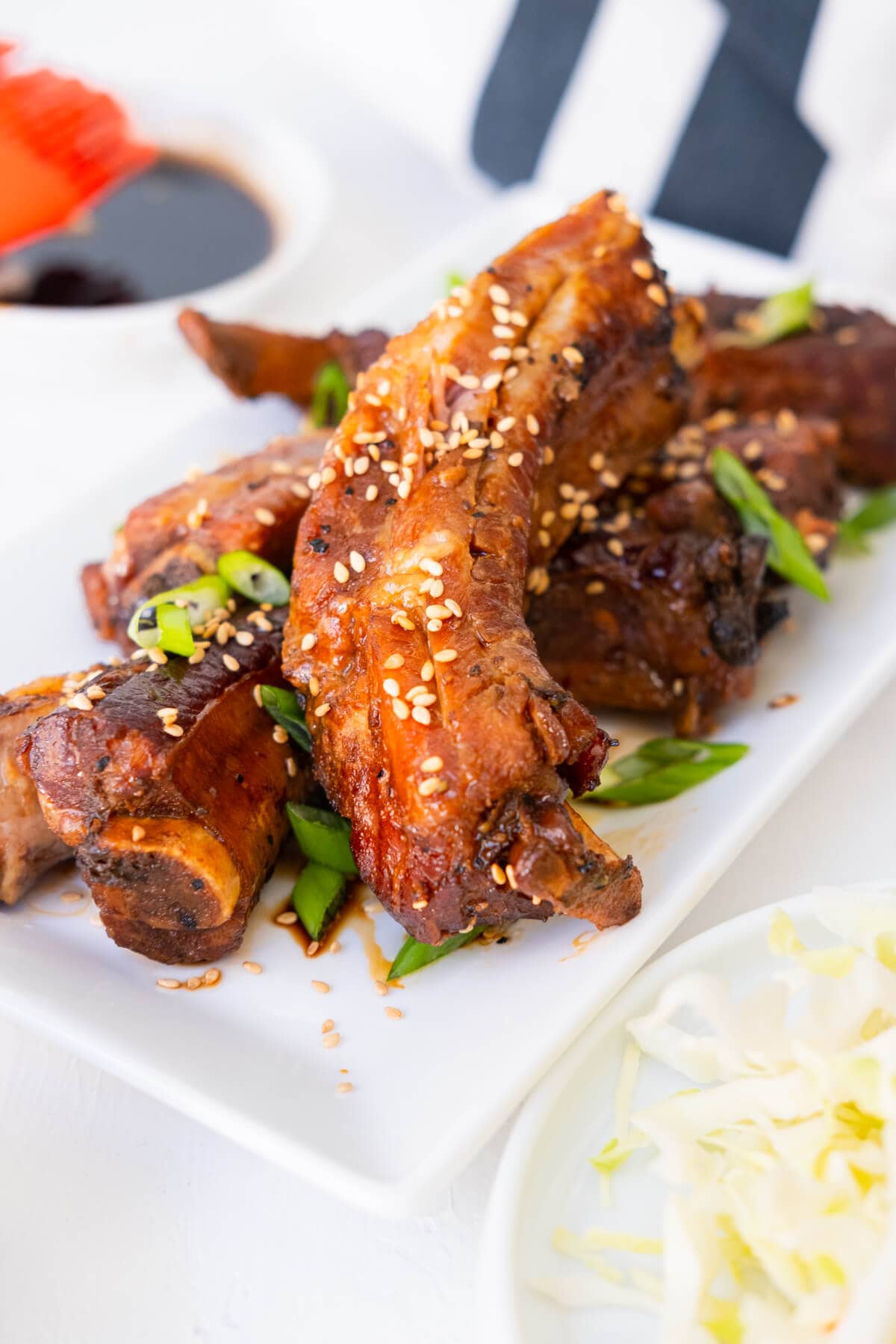 Slow cooker teriyaki ribs with white sesame seeds and chopped green onion on top.