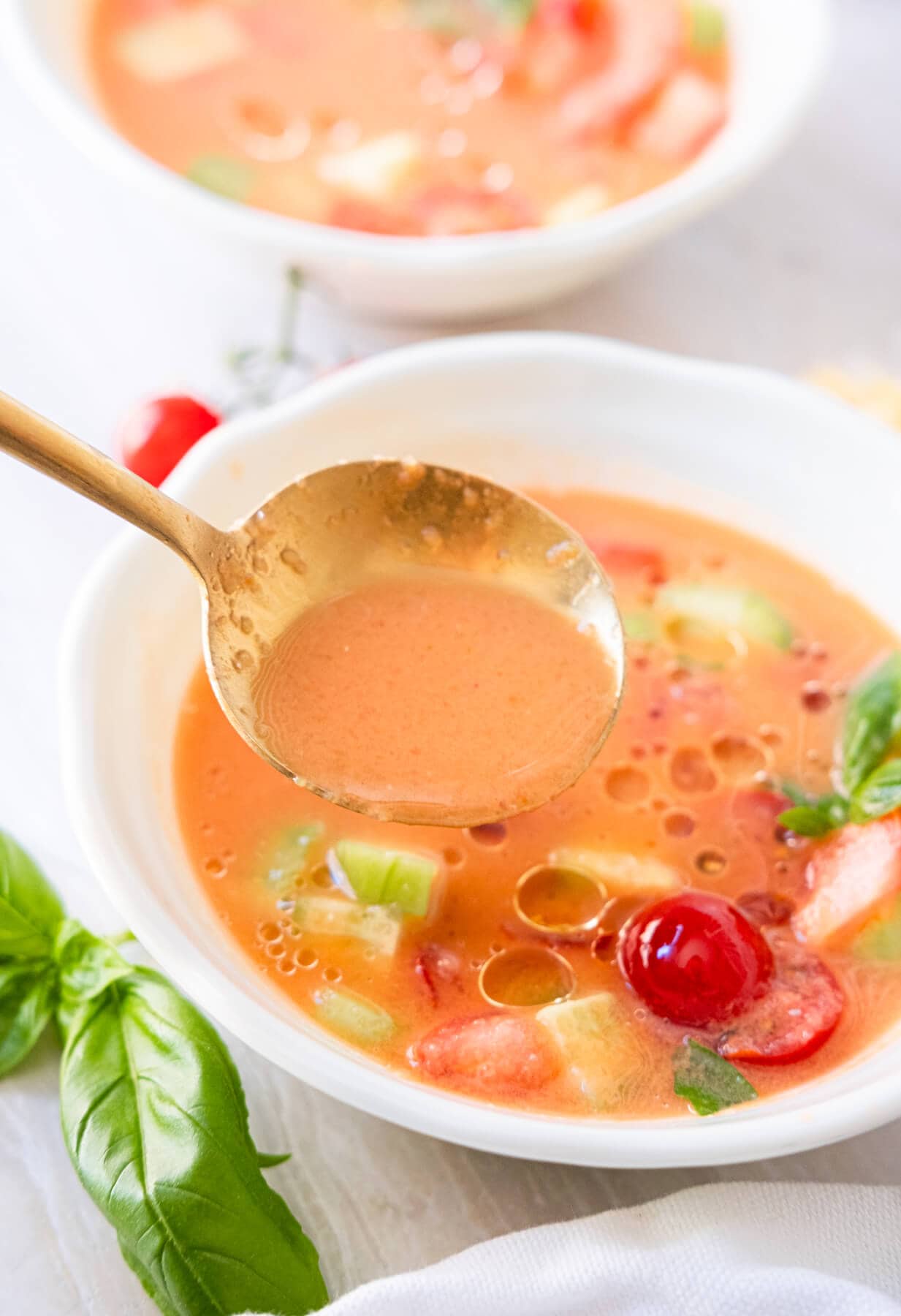 Spoon the gazpacho soup from a bowl. 