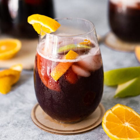 Spanish sangria with orange and green apple slices placed aside.