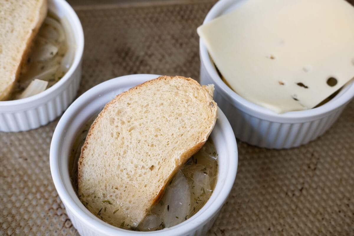 Ladle soup into oven-safe ramekins and topped with bread, three kinds of cheese and broil. 