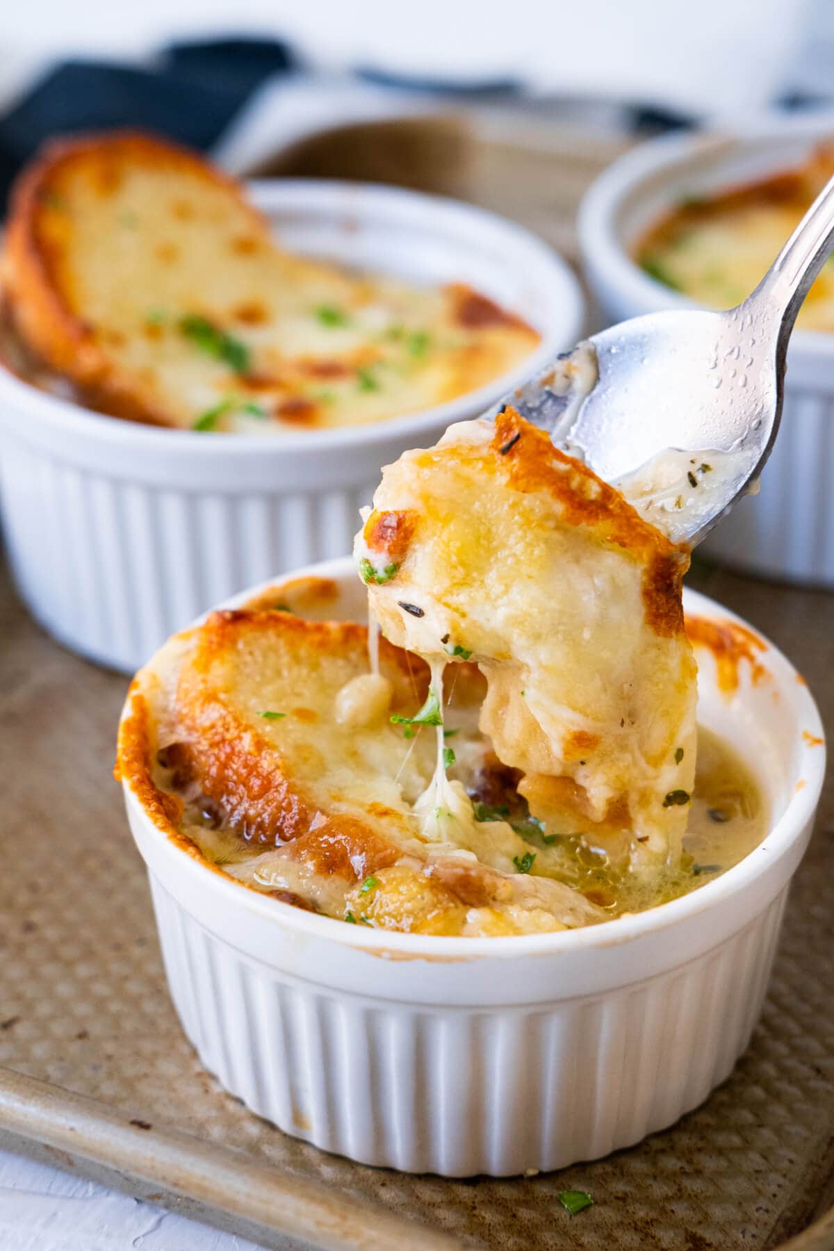 Cheese French onion soup scoop up with a fork of melty cheese and soggy bread. 