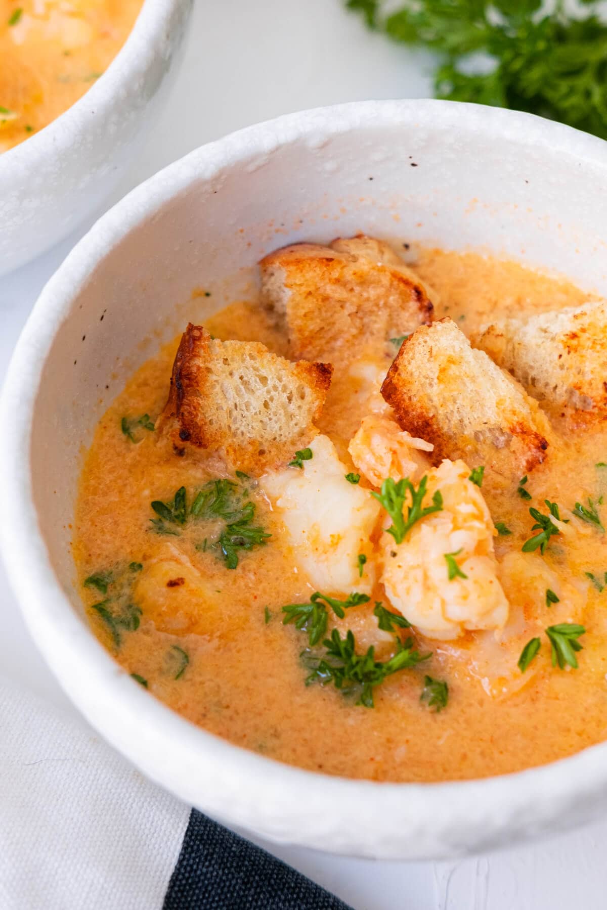 Shrimp bisque served with crouton and parsley on top. 