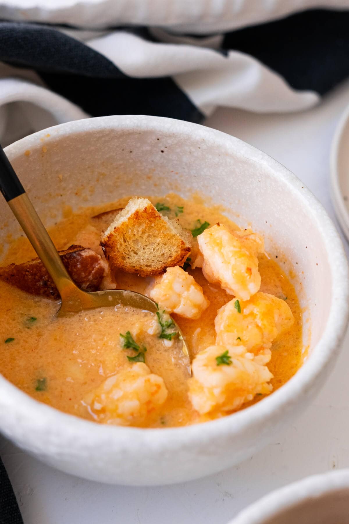 Scoop the shrimp bisque with a spoon. 