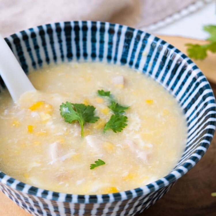 Sweet corn and chicken soup served with cilantro on top.